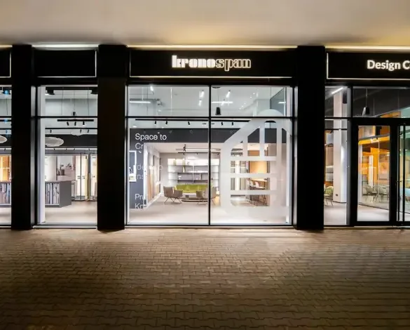 Vue extérieure nocturne du Design Center Kronospan à Casablanca – vitrines, éclairage architectural et aménagement bois