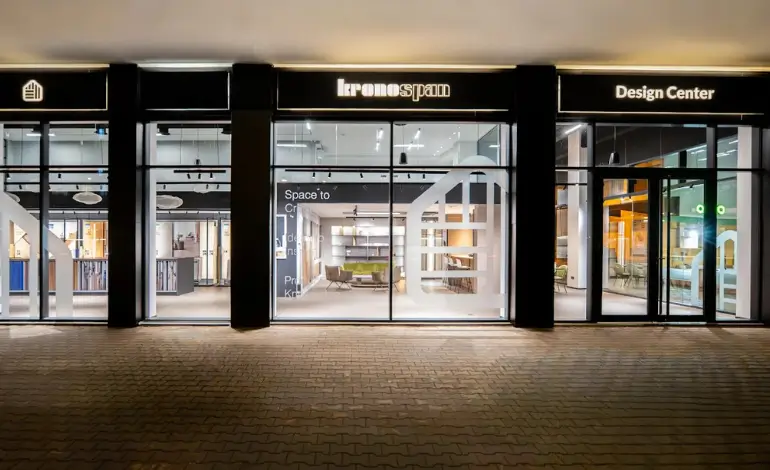 Vue extérieure nocturne du Design Center Kronospan à Casablanca – vitrines, éclairage architectural et aménagement bois