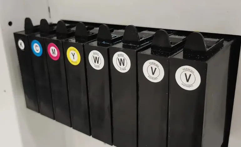 plan rapproché des cartouches CMYK + blanc + vernis d’une imprimante UV, illustrant la technologie utilisée pour l’impression directe sur bois.